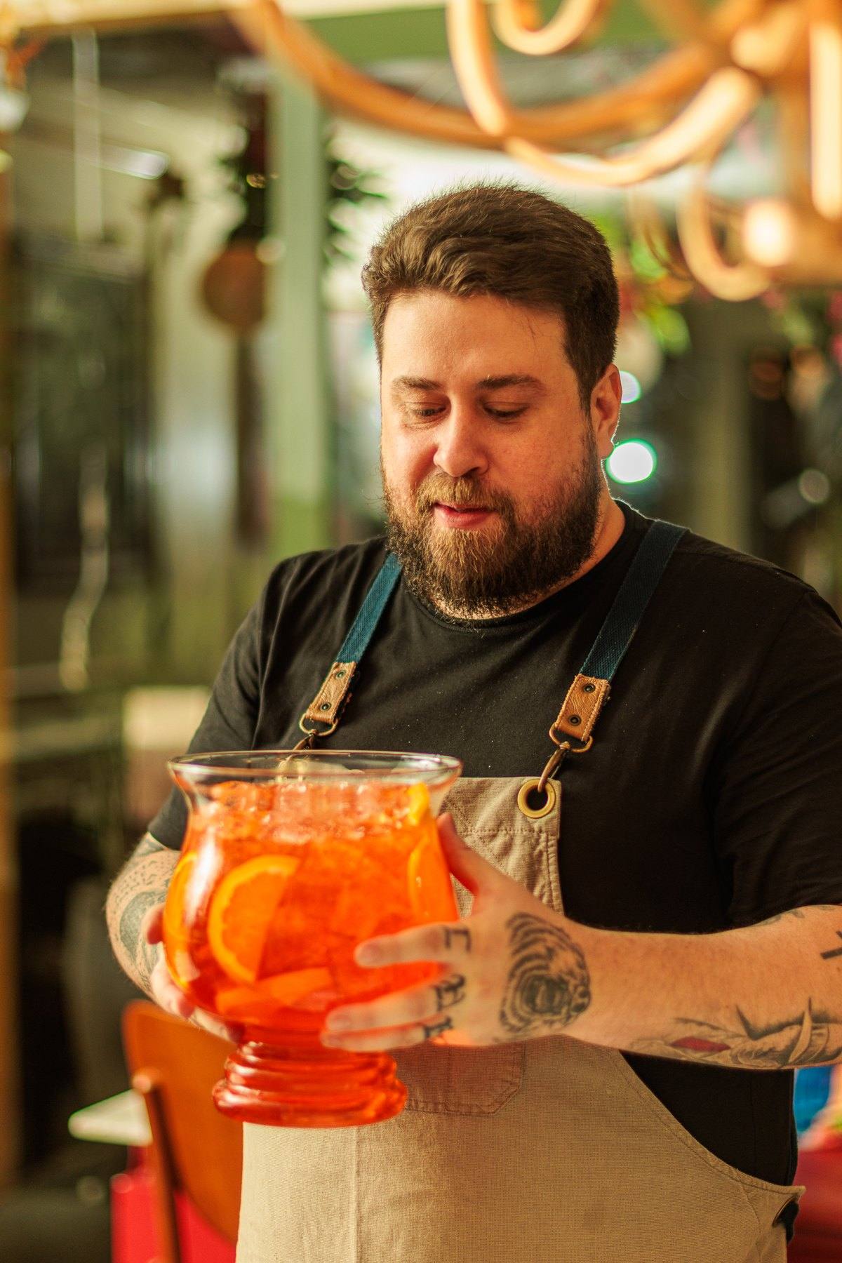 O Chef segurando uma taça gigante de Aperol Spritz no salão